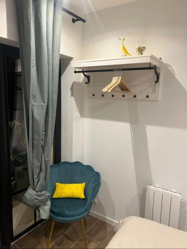- une chambre avec une chaise bleue et un oreiller jaune dans l'établissement Chambre indépendante proche du Circuit des 24h et du Pôle Européen du Cheval, à Yvré-lʼÉvêque