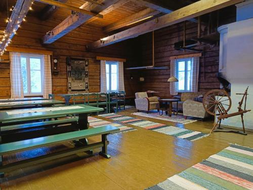 a room with tables and chairs in a wooden building at Jussila in Syöte