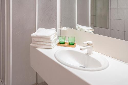 a white bathroom sink with towels and a mirror at Vero Living & more in Hoheneich