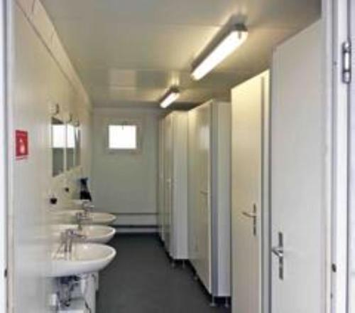 a row of three sinks in a public bathroom at F1 Camping Oostenrijk in Scheifling