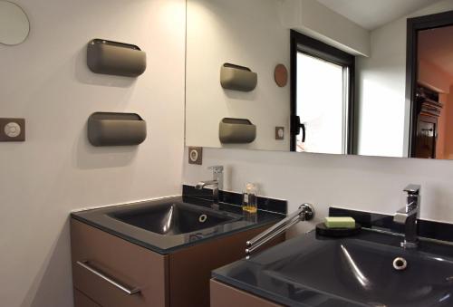 une salle de bain avec un lavabo et un miroir dans l'établissement Maison Klein 8 voyageurs proche Bordeaux, à Mérignac