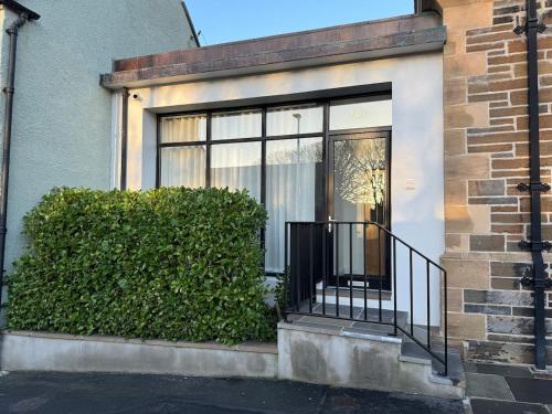 a house with a glass door and a bush at Old Library Apartments - 8a in Orkney