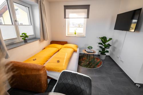 a living room with a couch and two windows at Moderne Wohnung in Seenähe! in Lengau