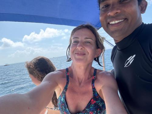 a man and a woman on a boat in the water at Liberty Guesthouse Maldives in Mahibadhoo