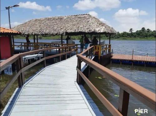 a wooden pier with a hut on the water at Refúgio em Barreirinhas Chalé in Barreirinhas