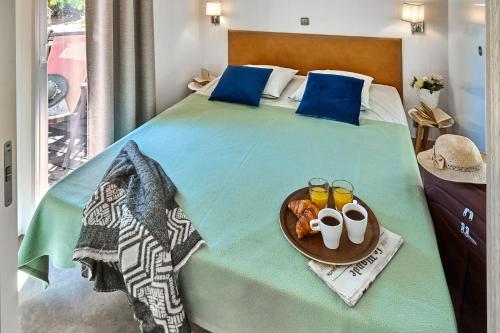 a bedroom with a bed with a tray of food on it at Au Paradis des Campeurs in Les Issambres