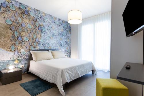 a bedroom with a bed and a blue wall at Hotel Nevada in Bellaria-Igea Marina