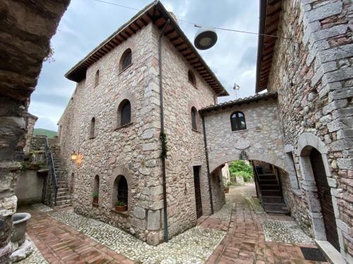 an old stone building with an archway at Il borgo di Firenzuola Camere con camino in Acquasparta