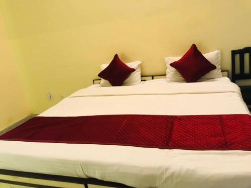 a bed with red and white sheets and pillows at Hotel Green Haveli - A Heritage and Hill View Hotel , Pushkar in Pushkar