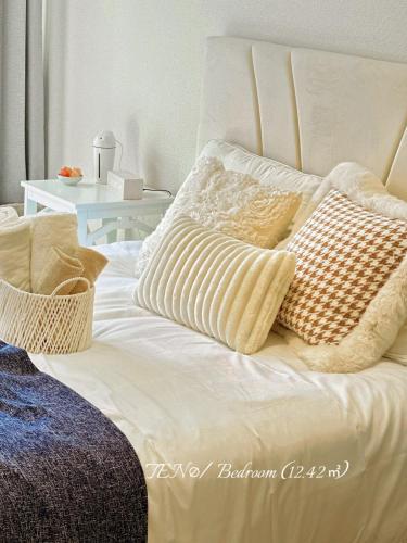 a white bed with pillows on top of it at Ten10 in Nagoya