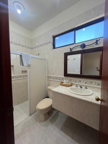 a bathroom with a sink and a toilet and a window at Hotel Caribe in Cozumel