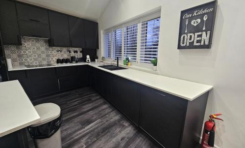a kitchen with black and white cabinets and a window at The Penthouse Tamworth Spacious 3 Bedroom Apartment in the town centre in Tamworth