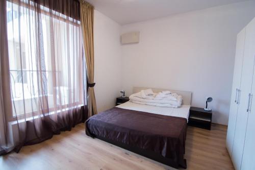 a bedroom with a bed and a large window at Cabacum Beach Private Apartaments in Golden Sands