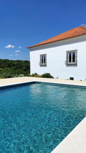 a swimming pool in front of a house at Torre da Giesteira in São Brissos