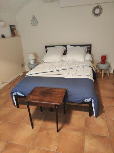 - un lit avec une table en bois dans une chambre dans l'établissement Studio Gite Mondragon (Vaucluse), à Mondragon