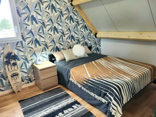 une chambre avec un lit avec un papier peint bleu et blanc dans l'établissement Villa Malgira, bord de mer, à Saint-Germain-sur-Ay