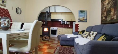 a living room with a blue couch and a kitchen at Fishta Villa and Apartments in Shkodër