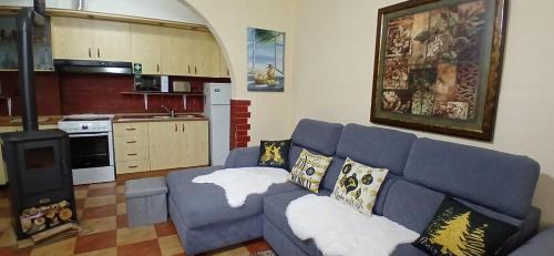 a living room with a blue couch and a kitchen at Fishta Villa and Apartments in Shkodër