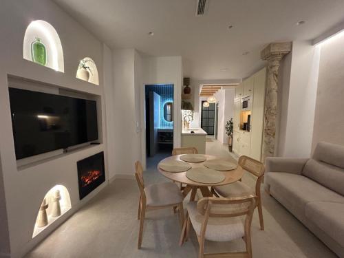 sala de estar con mesa, sofá y chimenea en Apartamento de lujo con piscina climatizada, en Nerja