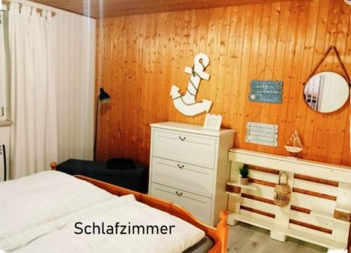 a bedroom with a bed and a wooden wall at Möwe 30 in Mirow