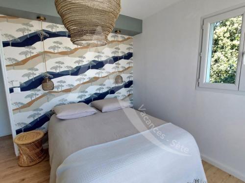 une chambre avec un lit avec un mur bleu et blanc dans l'établissement Super villa 6 personnes avec piscine et climatisation a cote des plages, à Sète