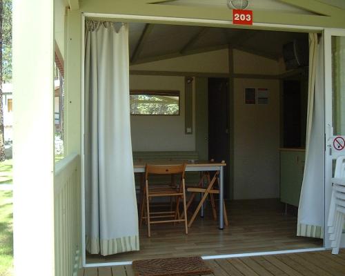 a room with a table and chairs in a house at Parque de Campismo Orbitur Valado in Nazaré