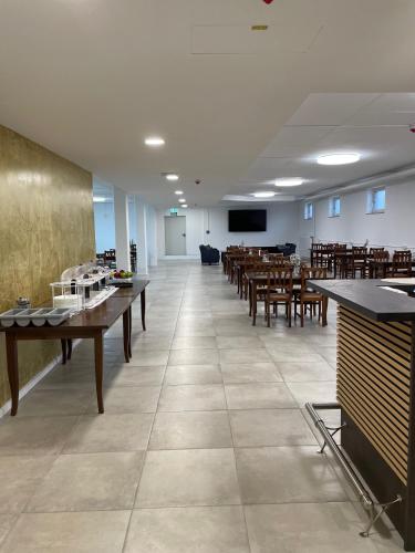 a large room with tables and chairs and a classroom at Gastpark Hotel in Manching