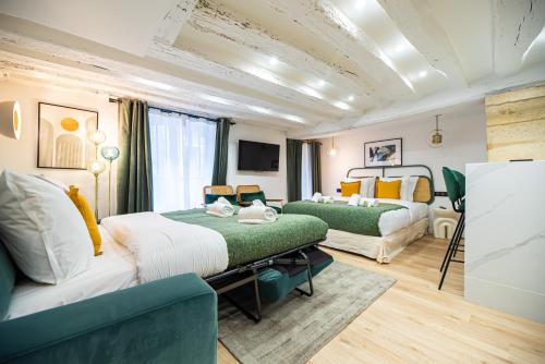 une chambre d'hôtel avec deux lits et une télévision dans l'établissement CIA - Studio in Heart of Le Marais 4P, à Paris