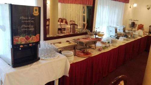 a long table with a counter with plates and food at Hotel Aranysas in Alsóörs
