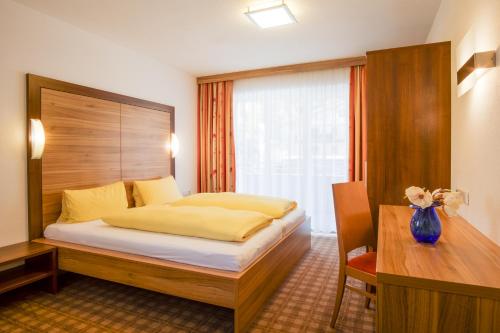 a hotel room with a bed and a desk at Apart Mado in Längenfeld