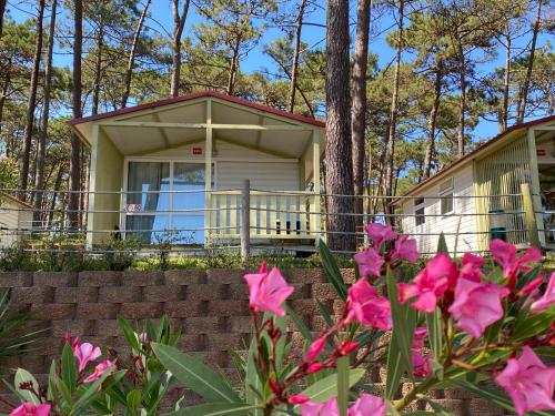 a house with pink flowers in front of it at Parque de Campismo Orbitur Valado in Nazaré