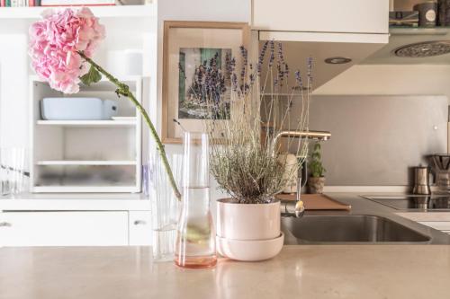 - un comptoir de cuisine avec un évier et un vase fleuri dans l'établissement Notre-Dame Stunning 2 BR air conditioned Flat, à Paris