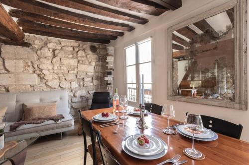 - une salle à manger avec une table en bois et un canapé dans l'établissement Notre-Dame Stunning 2 BR air conditioned Flat, à Paris