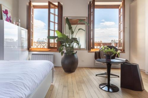 une chambre avec un lit et une table avec une plante dans l'établissement Notre-Dame Stunning 2 BR air conditioned Flat, à Paris