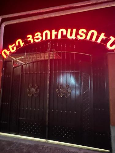 a neon sign on the door of a building at Red Family Hotel in Vagharshapat