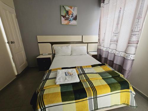 a bedroom with a bed with a colorful blanket on it at Hotel La Suite de Angelique Huacho in Huacho