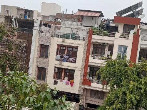 a tall white building with people sitting on a balcony at Vdev homestay in Prayagraj