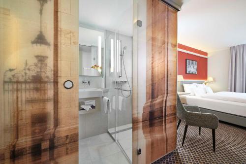 a bathroom with a shower and a bedroom with a bed at Best Western Hotel Leipzig City Centre in Leipzig