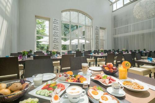 a table with breakfast foods on it in a restaurant at Best Western Plus Hotel Fellbach-Stuttgart in Fellbach