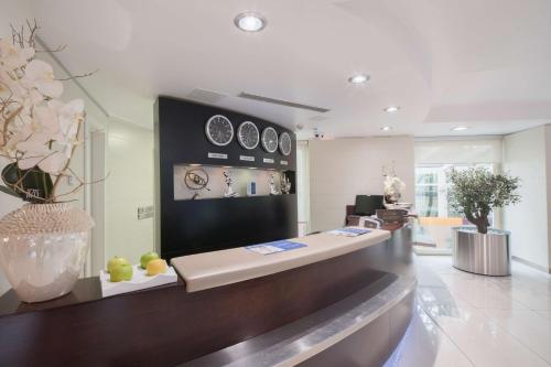 a lobby with a counter with clocks on the wall at Best Western Plus Grand Hotel Victor Hugo in Luxembourg