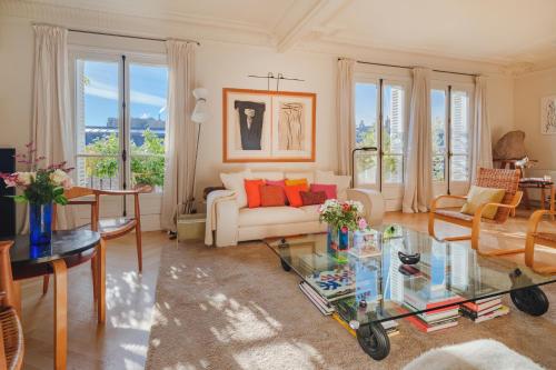 un salon avec un canapé blanc et une table en verre dans l'établissement Paris St Germain Loft residence, à Paris