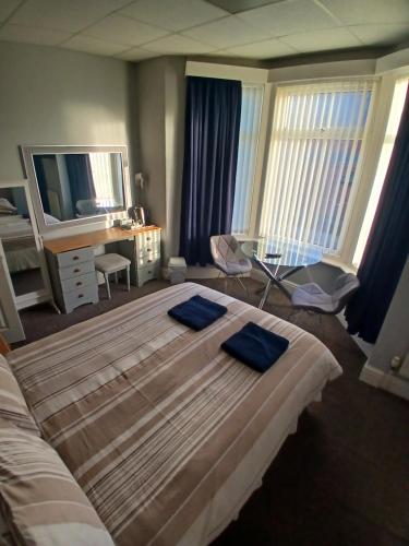 a bedroom with a large bed and a desk at The Kirkview in Blackpool