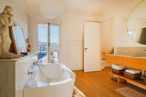 une salle de bain avec baignoire et une grande fenêtre dans l'établissement Paris St Germain Loft residence, à Paris