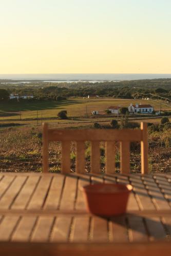 a wooden bench sitting on a table with a bowl at Monte Sardinha in Santiago do Cacém