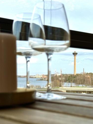 two wine glasses sitting on a window sill at Beautiful two-room apt with lake Näsijärvi views in Tampere