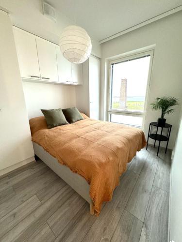 a bedroom with a large bed and a large window at Beautiful two-room apt with lake Näsijärvi views in Tampere