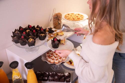 a woman standing in front of a buffet of desserts at Best Western Hotel Armando in Verona