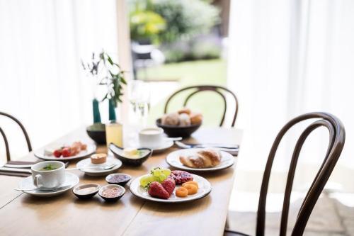 a wooden table with plates of food on it at Romantik Hotel Jagdhof in Caldaro