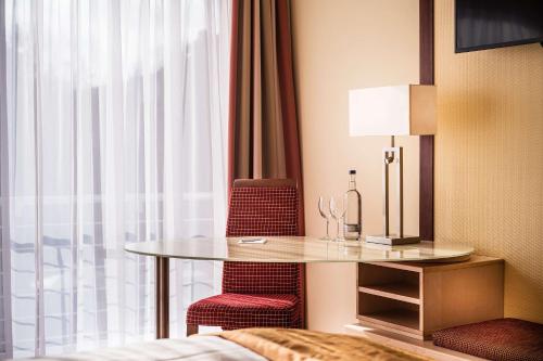 a room with a table and two chairs and a window at Best Western Plus Residenzhotel Lüneburg in Lüneburg