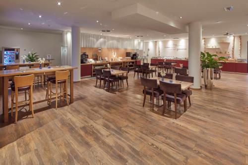 a restaurant with wooden floors and tables and chairs at Best Western Hotel Trier City in Trier